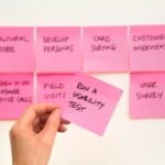 person holding pink sticky note